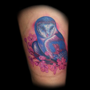 color owl and pink cherry blossom flowers tattoo